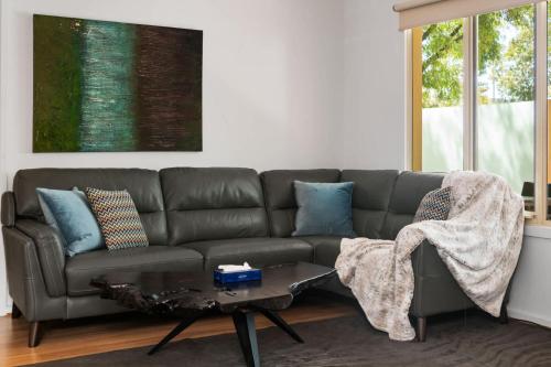 a living room with a couch and a table at Family friendly CBD 3BR Apt Hurtle Square in Adelaide