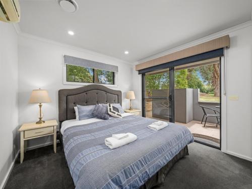 a bedroom with a bed with two towels on it at Lake View Villa in Lake Hume
