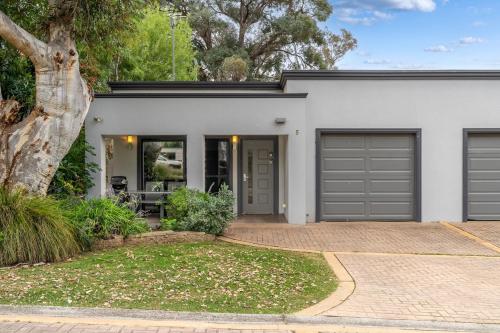 a white house with grey garage doors at Lake View Villa in Lake Hume