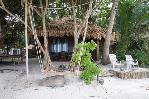 a hut on the beach with chairs and a swing at Lazy Hut in Ko Phayam