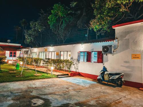 a motorcycle parked in front of a building at night at Sands Courtyard in Tajpur
