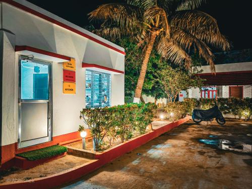 a building with a palm tree in front of it at Sands Courtyard in Tajpur