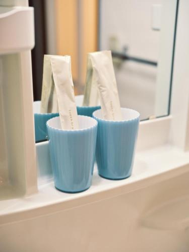 three blue cups sitting on a shelf in front of a mirror at vetta kumamoto sakuramachi 603 in Kumamoto