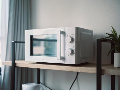 a microwave oven sitting on top of a shelf at vetta kumamoto sakuramachi 603 in Kumamoto