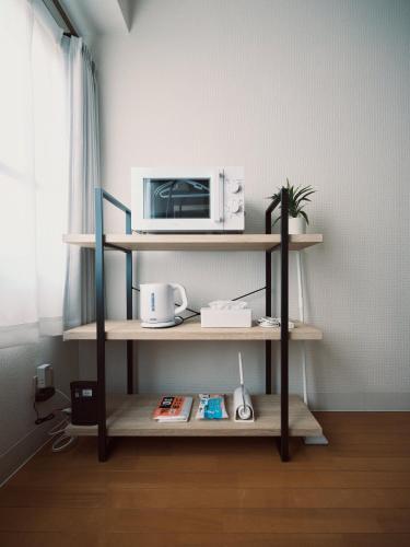 a microwave oven sitting on a shelf in a room at vetta kumamoto sakuramachi 603 in Kumamoto
