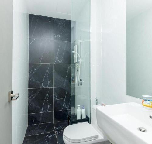 a bathroom with a shower and a toilet and a sink at The Floral Retreat N3w Cozy High floor Beacon Executive Suite in George Town