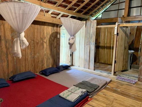 a large bed in a room with curtains at Dak Drinh Lodge in Dak Klong