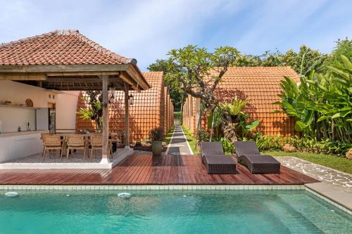a backyard with a pool and a table and chairs at Omaneil Villa in Uluwatu