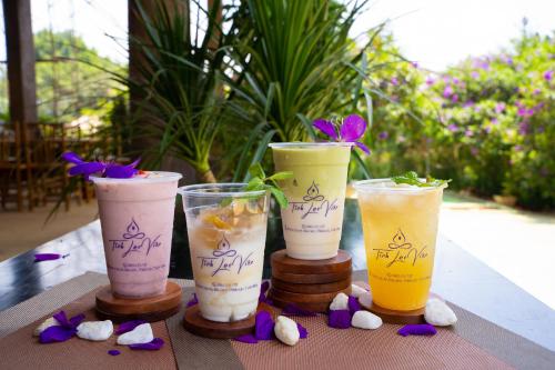 a group of four cups sitting on a table with flowers at Tĩnh Lạc Viên Homestay Bảo lộc in Bao Loc