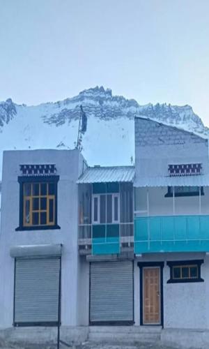 加沙Lhaksam Homestay By StayApart的山前有一栋带两个车库门的白色建筑