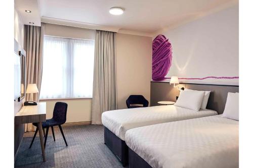 a hotel room with two beds and a desk at Exeter Rougemont Station Experience By Palette Resorts in Exeter