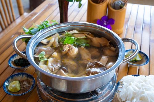 a pot of soup sitting on a table at Tĩnh Lạc Viên Homestay Bảo lộc in Bao Loc