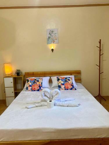 a bedroom with a bed with a cup on it at R&A Haven Guest House in San Juan
