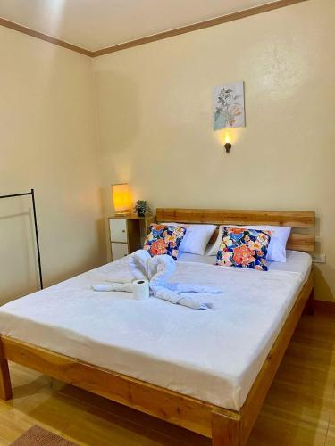 a bedroom with a large bed with white sheets at R&A Haven Guest House in San Juan