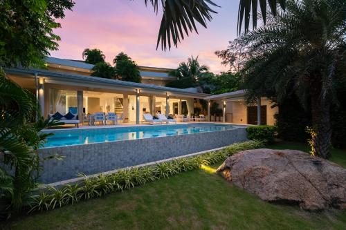 an exterior view of a house with a swimming pool at Villa Maliya in Plai Laem