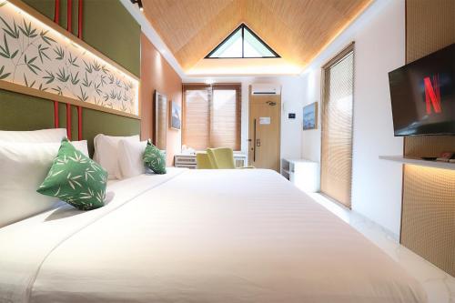 une chambre avec un grand lit blanc dans une pièce dans l'établissement Moritz Hill Borobudur Resorts & Spa, à Borobudur