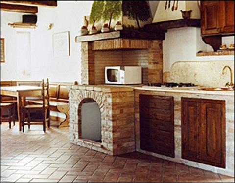 a kitchen with a fireplace in the middle of it at Agriturismo Oddone in Bardineto