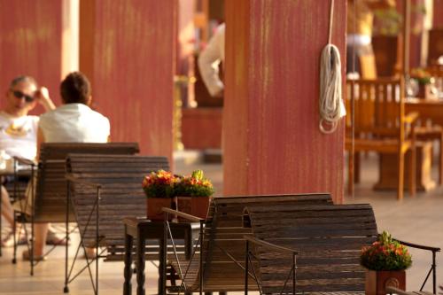 two people sitting at tables and chairs in a restaurant at Amaya Hills Kandy in Kandy