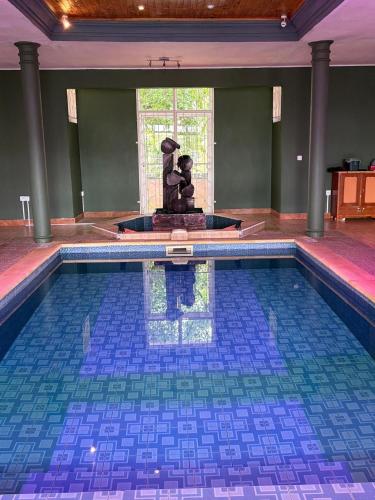 a swimming pool with a statue in the middle of it at Lariad BNB in Rivière Noire