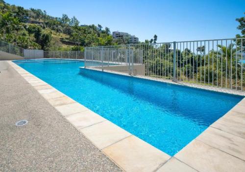 una gran piscina azul con una valla en 52 Airlie Beach Beauty at The Summit, en Airlie Beach