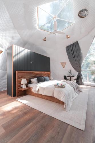 a bedroom with a large bed and a large window at RESET Tallebudgera Valley in Upper Tallebudgera