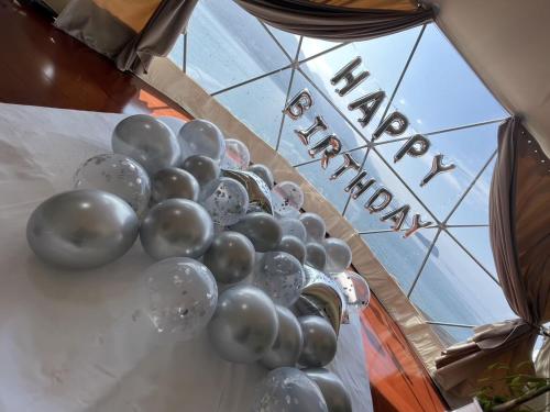 a bunch of balloons on a table with the wordulum at ITOSHIMA SDGs Village Chikyu MIRAI -海の大パノラマ-全室オーシャンビューのドームテント in Itoshima