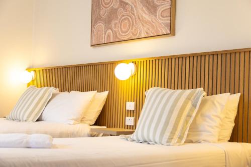 a hotel room with two beds with white pillows at High Street Motel in Echuca