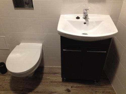 a bathroom with a white sink and a toilet at Hôtel Le Saint Amand in Saint-Amand-Montrond