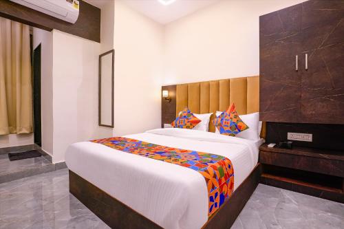 a bedroom with a large bed with a wooden headboard at FabHotel Gateway in Mumbai