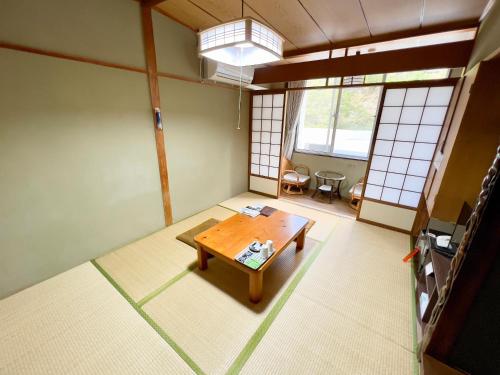 a room with a table in the middle of a room at 国民宿舎古岩屋荘 in Higashi-komi