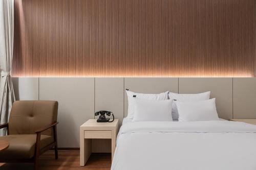 a bedroom with a large bed and a chair at Guwol Rondo Hotel in Incheon