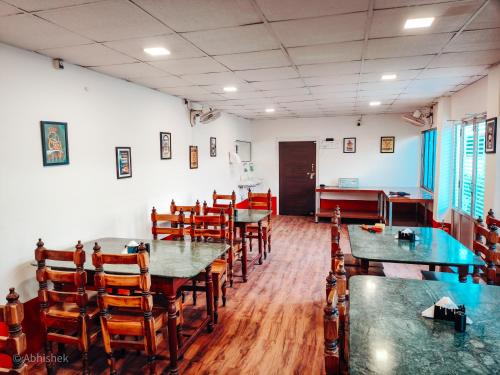a dining room with tables and chairs in a restaurant at Sands Courtyard in Tajpur