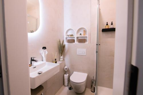 Un baño con inodoro, lavabo y ducha. en Krivoo Apartments II-Private Parking, en Košice