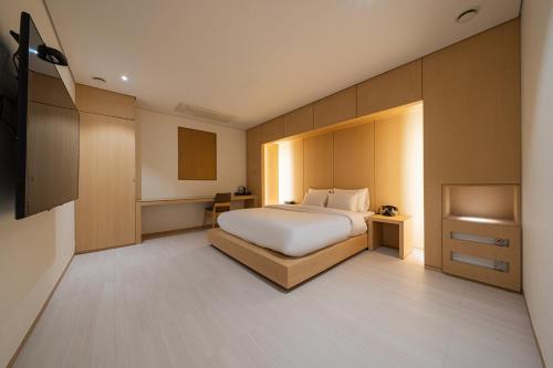 a bedroom with a bed with a white bedspread at Guwol Rondo Hotel in Incheon
