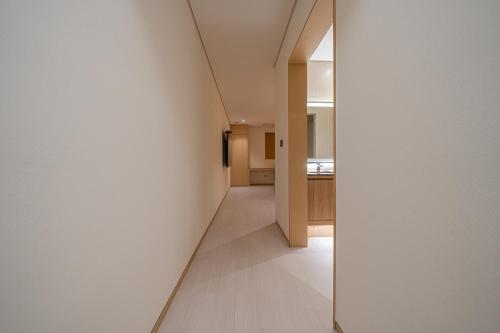 a hallway with a white wall and a mirror at Guwol Rondo Hotel in Incheon