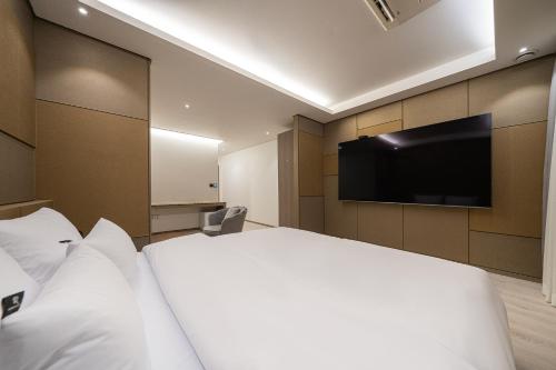a hotel room with a bed and a flat screen tv at Guwol Rondo Hotel in Incheon