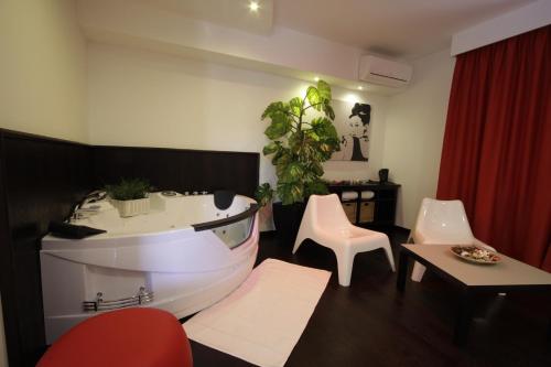 a living room with a white tub and a table at Hotel Paradise Airport in Forlì