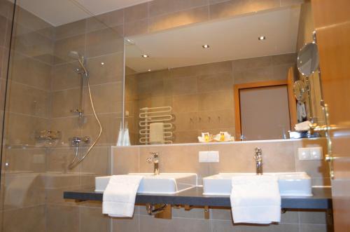 a bathroom with two sinks and a mirror at Hotel Jäger - family tradition since 1911 in Vienna