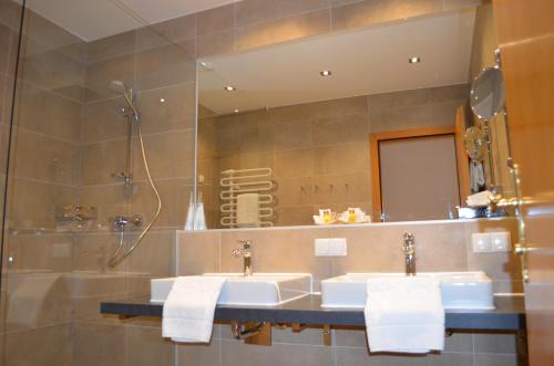 a bathroom with two sinks and a mirror at Hotel Jäger in Vienna