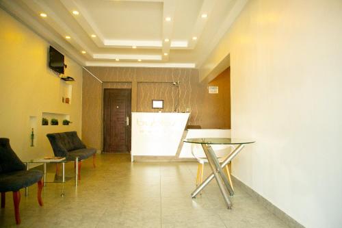 a lobby with two tables and chairs and a white screen at Byblos Hotel-Sky Osu in Accra