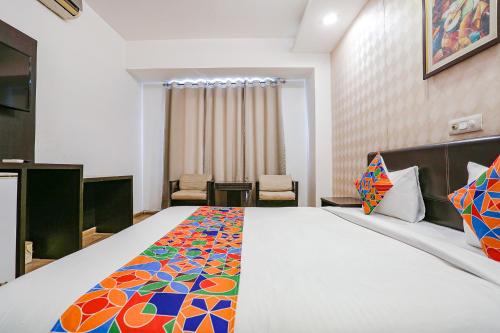 a bedroom with a large bed with a colorful blanket at FabHotel Premium Nest Near Golf Course Road in Gurgaon