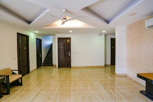 a living room with a ceiling fan and wooden floors at FabHotel Premium Nest Near Golf Course Road in Gurgaon