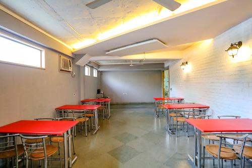 a row of red tables and chairs in a room at FabHotel Premium Nest Near Golf Course Road in Gurgaon