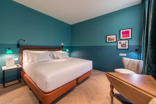 a bedroom with a bed and a desk and a table at Vincci The Mint in Madrid