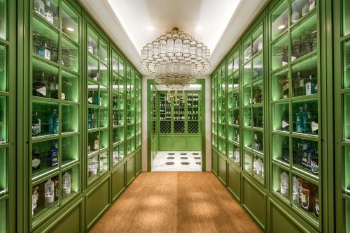 a green walk in pantry with green cabinets and a chandelier at Vincci The Mint in Madrid