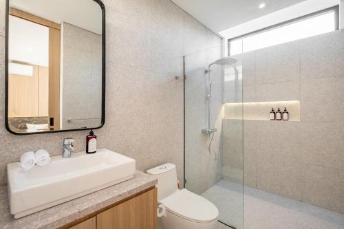 ein Badezimmer mit Waschbecken, Toilette und Dusche in der Unterkunft Private Villa Ayra 8D by OriVista 10min to Melasti Beach in Uluwatu