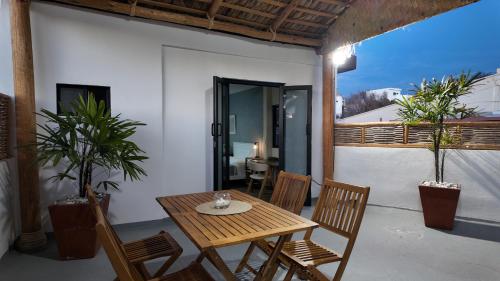 a wooden table and chairs on a patio with plants at MarJor Suites in La Paz