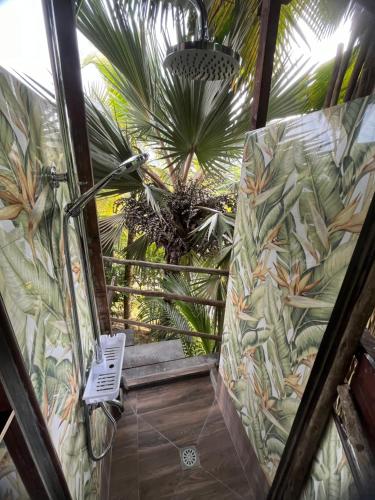 an open door to a bathroom with a palm tree at Royal Bay Villa in Anse Royale