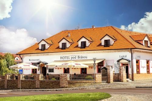 a building with an orange roof on a street at Hotel Pod Bránou in Bardejov