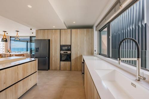 a kitchen with wooden cabinets and a large window at Legend Hill Resort and Spa in Rivière Noire